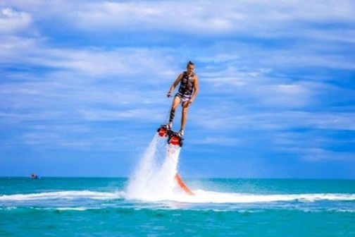 a man flying through the air while riding a wave in the ocean