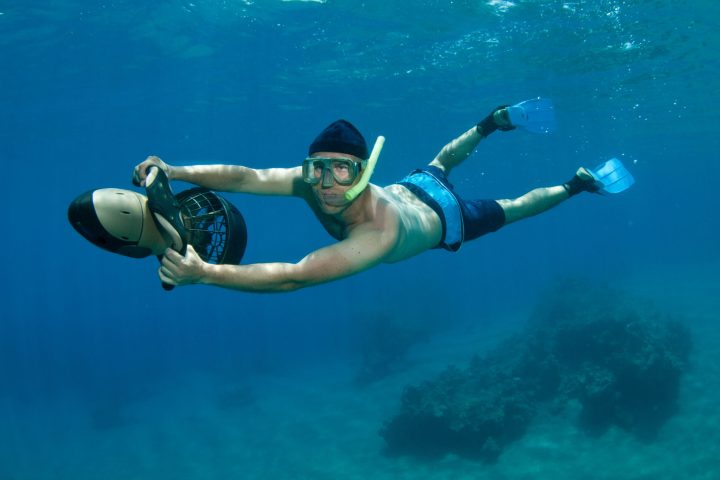 a man flying through the air while swimming in a body of water