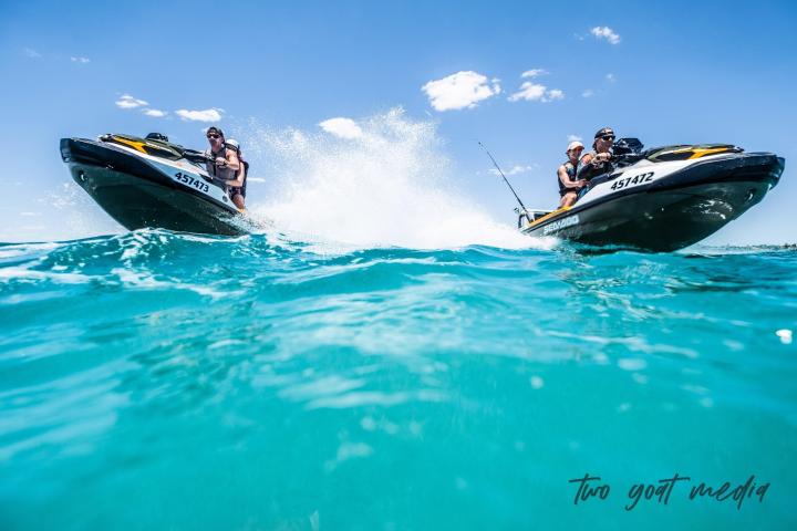 a man riding on the back of a boat in the water