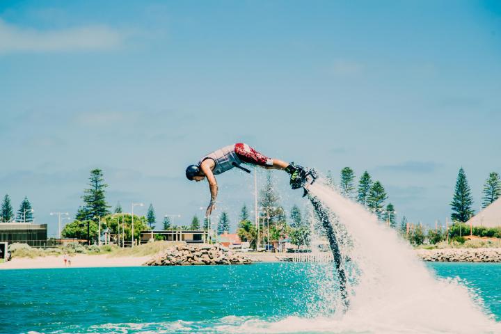 a man flying through the air over a body of water