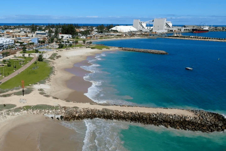 a group of people on a beach near a body of water