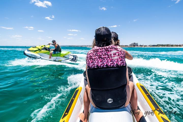 a group of people riding on the back of a boat in the water