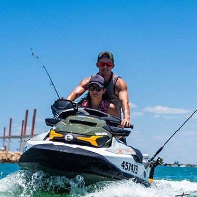 a man riding on the back of a boat in the water