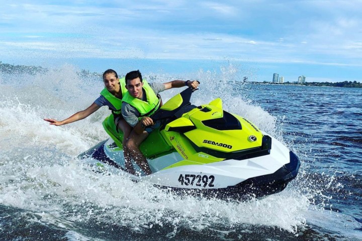 a man and woman riding a jetski on top of a body of water