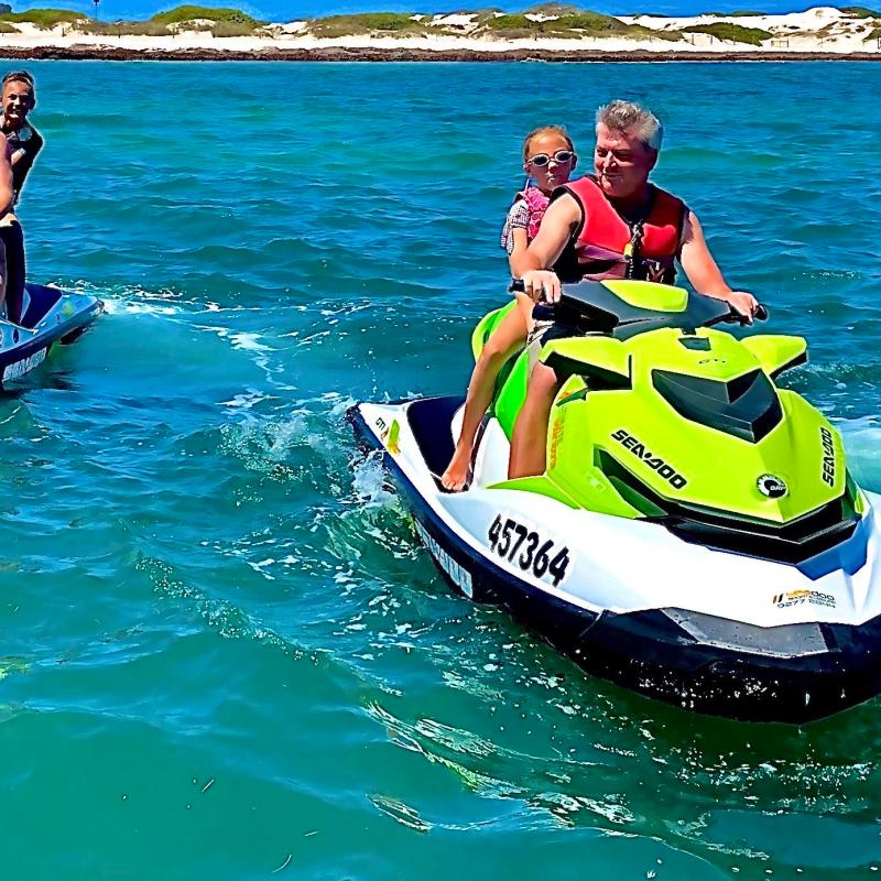 a man riding on the back of a boat in the water