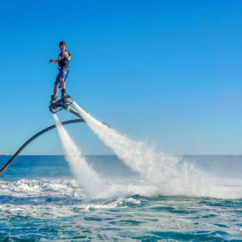 a man flying through the air while riding a wave in the ocean