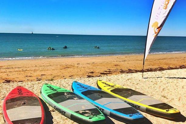 a beach with a surf board in the sand