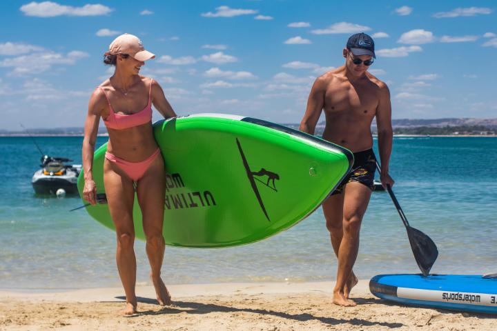 a couple of people that are standing in the sand on a beach